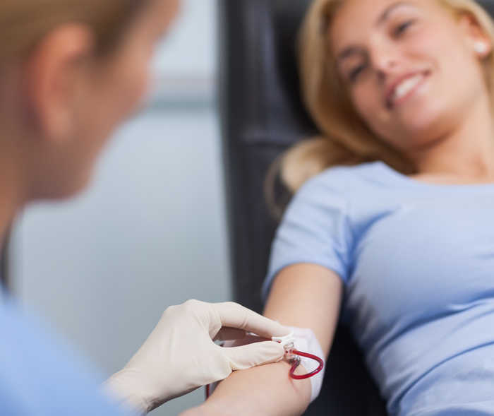 Eine Frau, der Blut über den Arm entnommen wird.