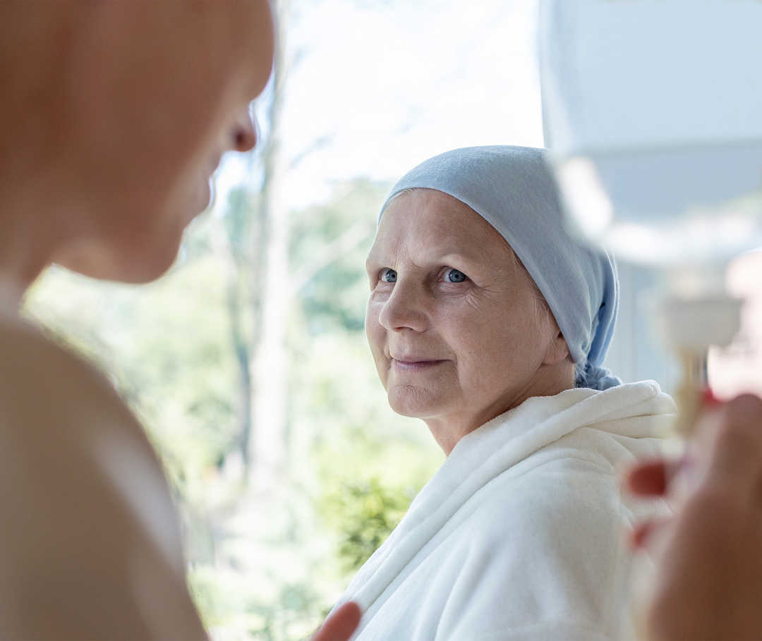 Ältere Patientin lächelt in die Kamera.