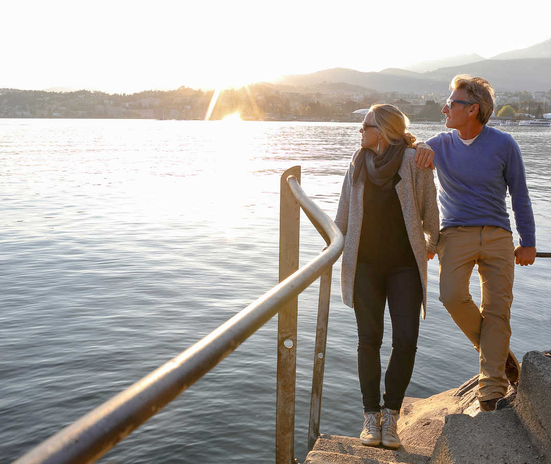 Un couple se tient sur un ponton et regarde l'eau.