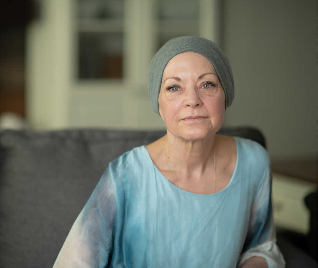 Une femme la tête couverte d’un foulard regarde l’objectif de l’appareil photo.